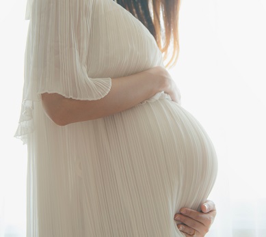 Side view of pregnant women in a white robe