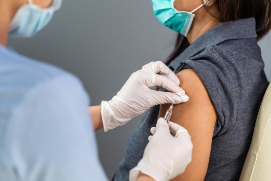 Nurse giving a vaccination shot for CAPWHN webinar on vaccination hesitancy